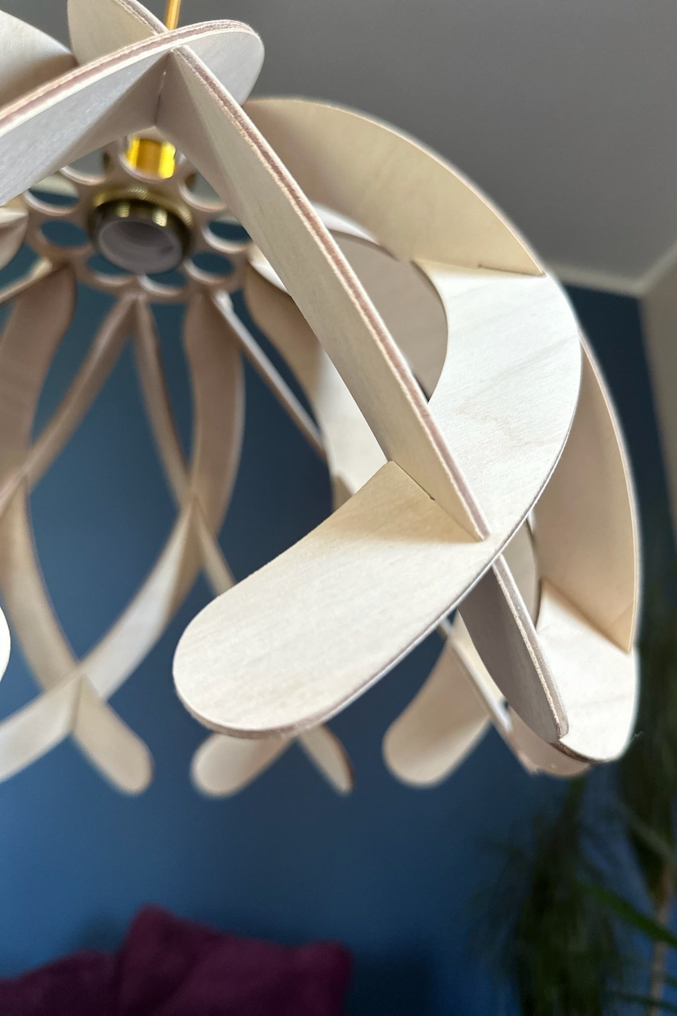 Close-up of a natural birch wood pendant lampshade, showcasing the smooth, rounded wooden ribs with gentle curves. The gold socket adds a touch of elegance to the simple and versatile design.